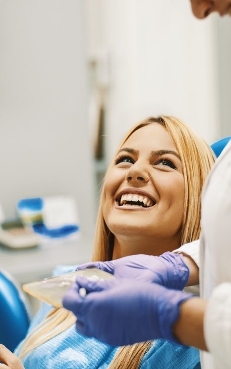 Woman in dental chair smiling at dentist