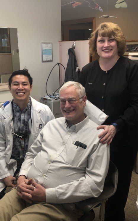 Dentist and dental patient smiling in dentistry treatment room with dental patient