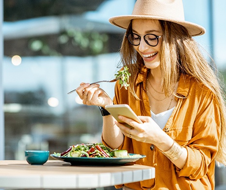 Woman smiling while eating lunch outside