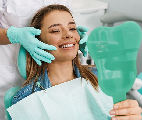 patient smiling in dental mirror 