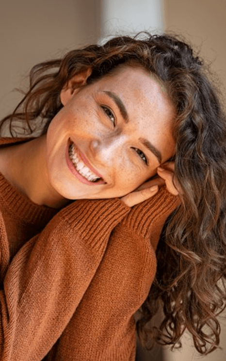 a woman smiling after receiving her CEREC same-day crowns