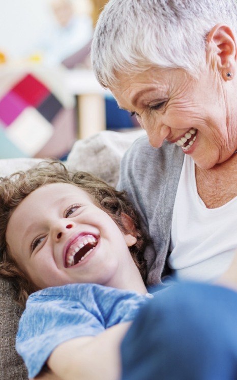 Smiling older woman with grandchild enjoying the benefits of dental implants