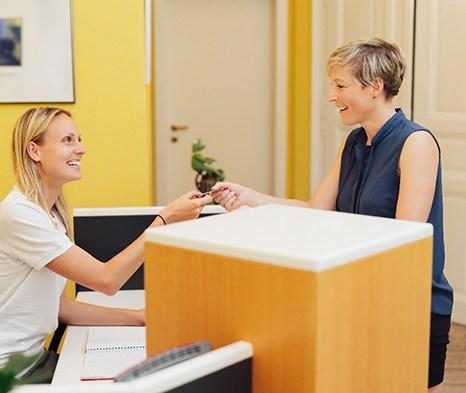 A woman paying the cost of Candid Pro clear aligners