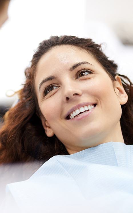 Person smiling while sitting in dental treatment chair