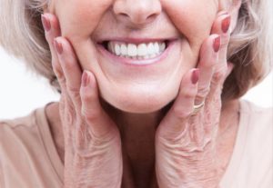 a woman smiling and showing her smile with dentures