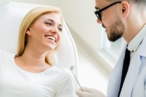 Woman in white shirt smiling at dentist 