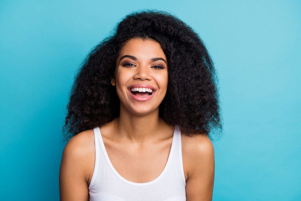Woman in white tank top smiling