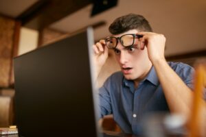 man looking surprised looking at his computer